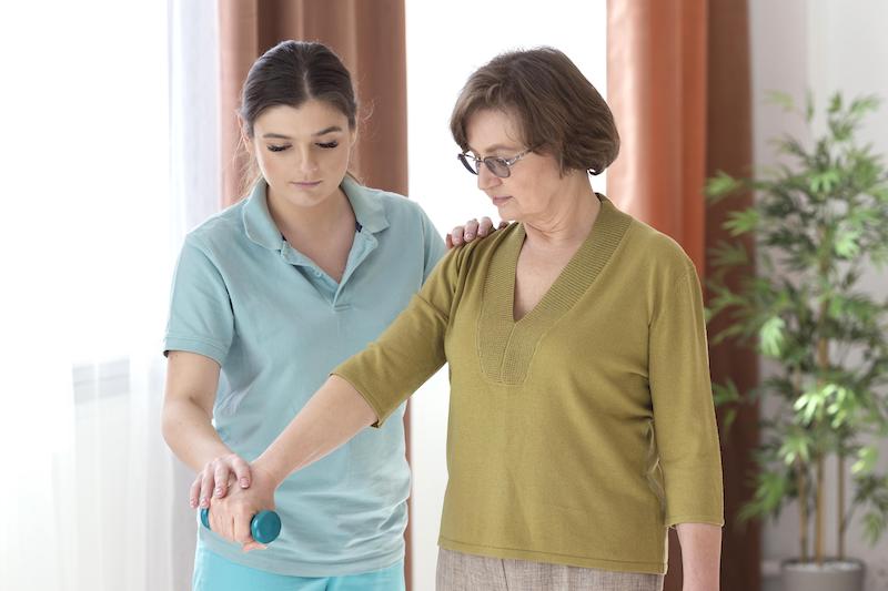 Kvinna som hjälper en äldre dam